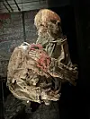 The skeleton of one of the Uvdal girls is displayed in a glass case. Traces of a red mitten are especially visible on her left arm. Her face is turned away from visitors and toward the wall, out of respect for the deceased.