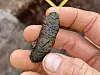 A hand holding a small brown lump