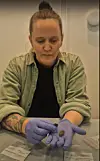 Anette Sand-Eriksen holds the lump of resin in gloved hands.