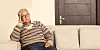 An older man sitting on a sofa