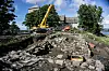 Photograph from the 2017 excavation of the royal estate. The remains of the stone walls are visible, along with an excavator and the church in the background.