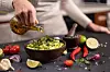 Person drizzles oil over food.