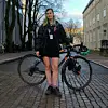 Person standing in front of their bike outdoors on the street