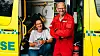 Two researchers stand by an ambulance with the rear doors open during a field study.