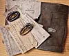 Papers and a dark leather wallet lie on a chair together with two old, brown condoms.