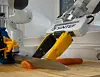 Three robotic arms work around a piece of salmon on a cutting board in a laboratory.