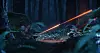 Orange light beam crossing a dark forest floor with rocks and ferns at night.