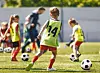 Young children playing football.