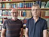 Two men photographed in front of a bookshelf.