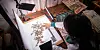 Researcher examining dried plant specimens and records at a worktable at Kew Madagascar.