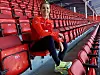 Andrine Hegerberg sits in a red stadium seat wearing Brann training attire.