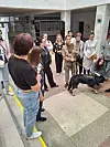 A group gathers around a therapy dog during a TURBO programme session indoors in Ternopil.