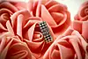 A ring of diamonds lies among tightly clustered pink roses.