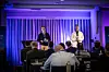 Two men on a purple-lit stage to an audience at the High North Dialogue conference.
