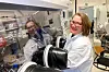 Researcher in a white lab coat works beside glovebox equipment in an NTNU battery laboratory.