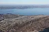Aerial view of Nuuk Airport, rocky hills, scattered buildings and coastal waters in Greenland.