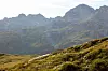 Rugged Austrian Alpine peaks above a sunlit grassy hillside