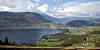Mountain valley surrounding Lake Vangsvatnet, with villages, fields and a cloudy sky.