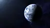 Half-illuminated Earth with blue and white clouds floating against a dark, star-filled space background.